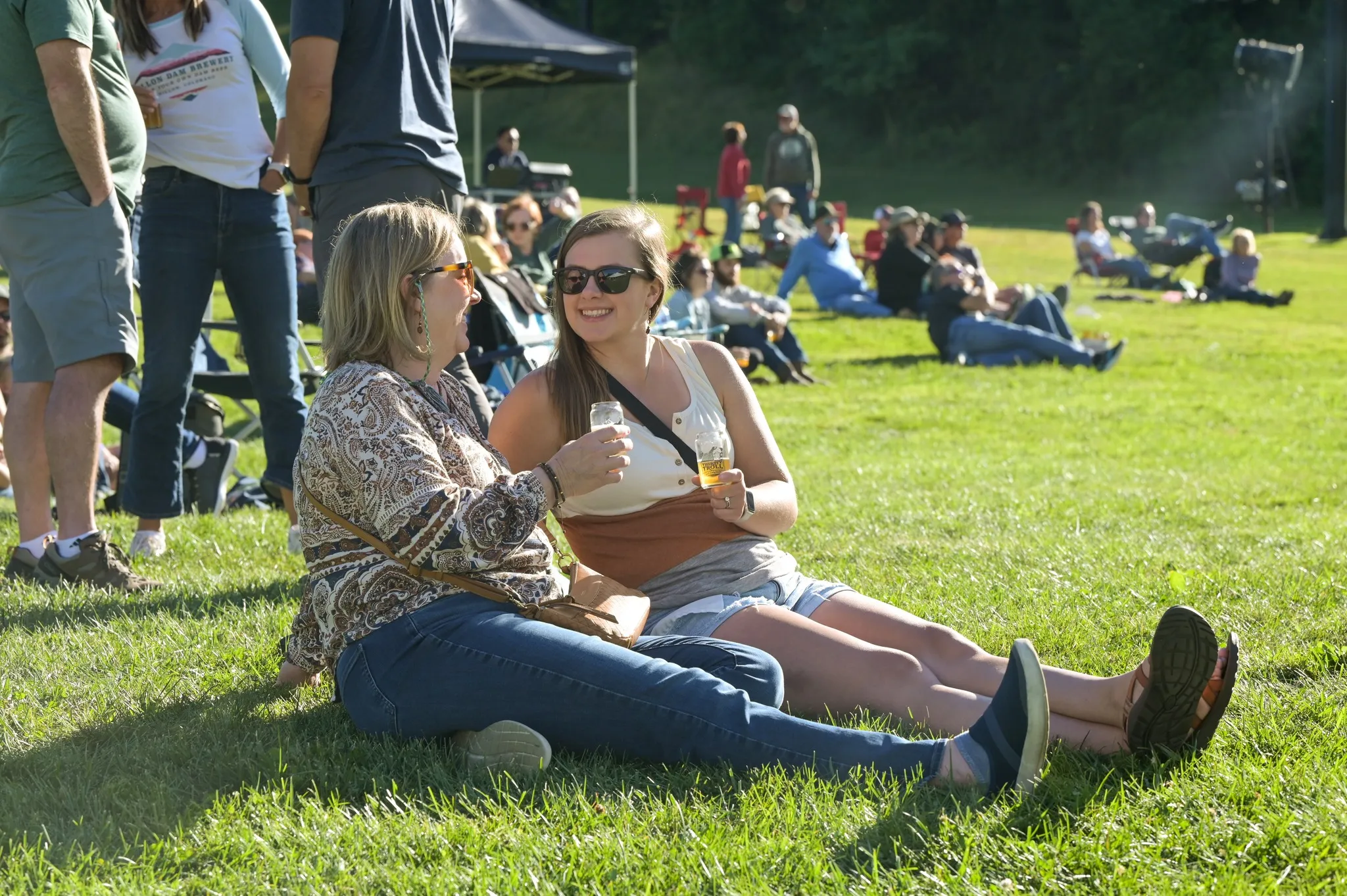 Guests sitting in grass enjoying a NA beer