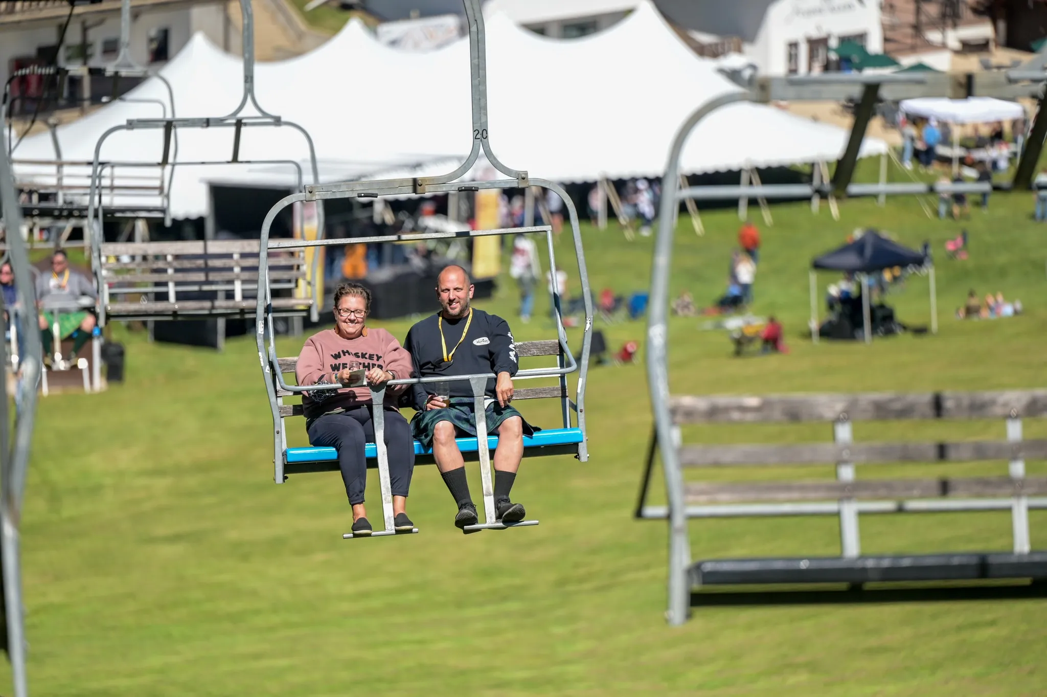 Guests riding ski lift with the beer tent in the background